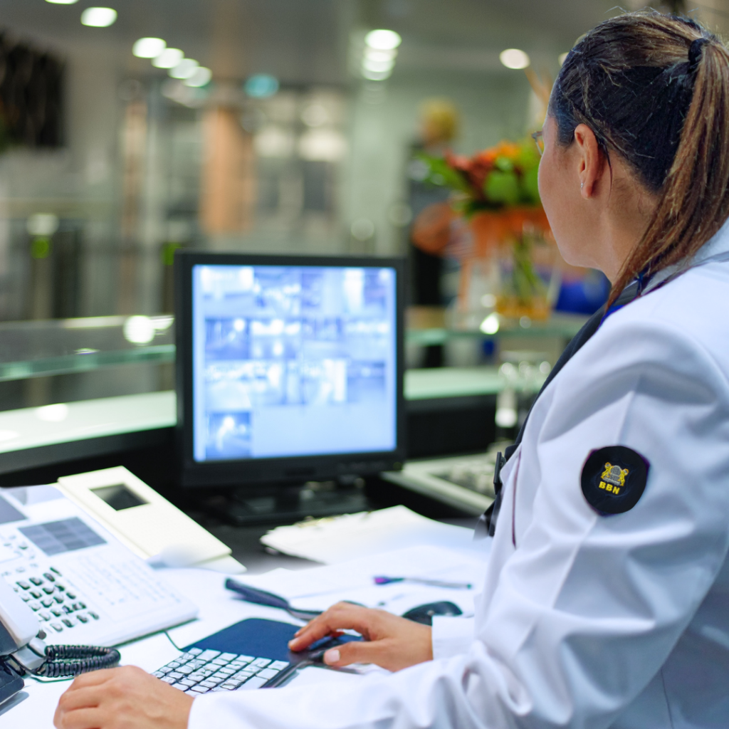 Beveiliger van BBN Beveiliging achter receptiebalie met cameratoezicht en monitoring van een bedrijfslocatie