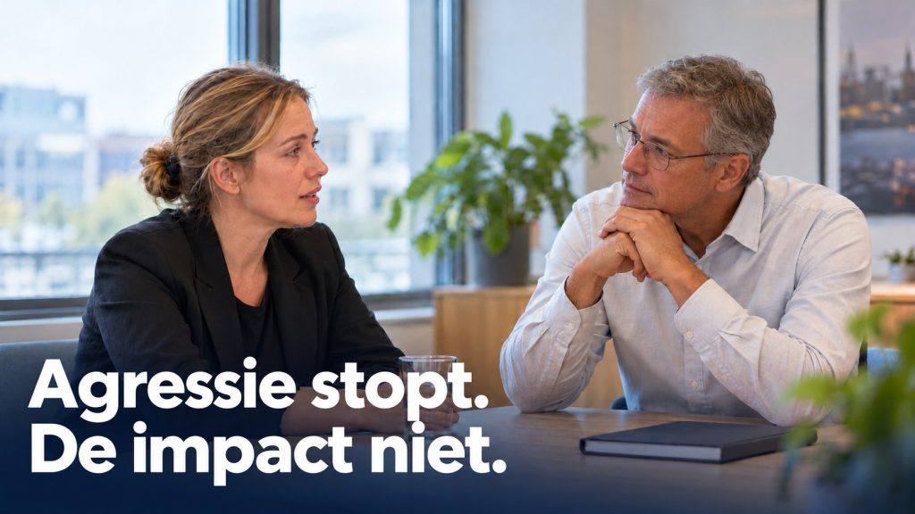 Medewerker en manager voeren een rustig nazorggesprek aan een tafel in een kantoor.